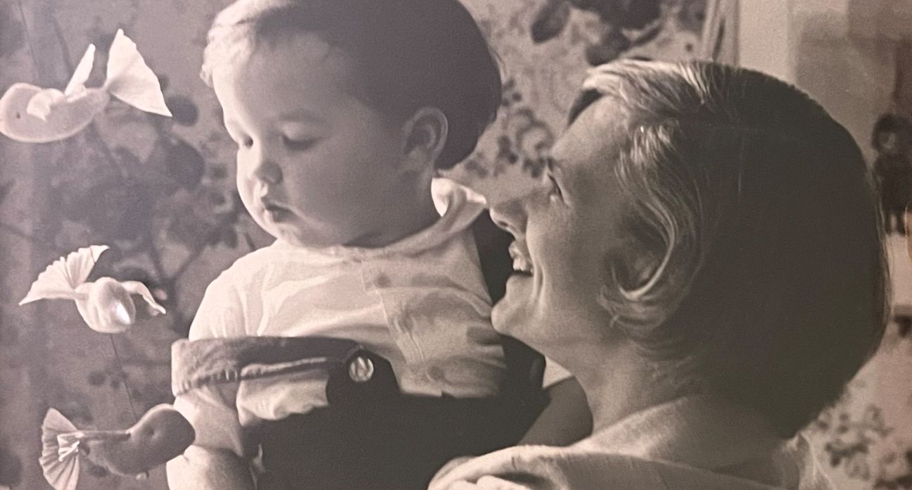 A black and white image of a woman holding a baby and smiling.